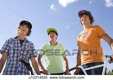 Teenager triplets laughing with bikes View Large Photo Image Stock Photography - Teenager triplets laughing with bikes. Fotosearch