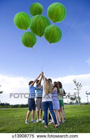 Teenagers holding helium green balloons View Large Photo Image Stock Photography - Teenagers holding helium green balloons. Fotosearch