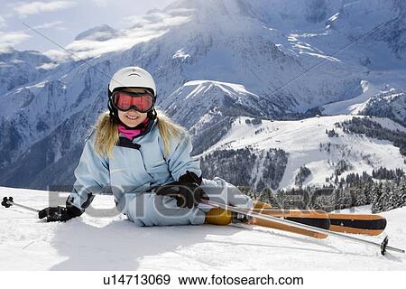 Girl with skis lying on the snow View Large Photo Image Stock Photo - Girl with skis lying on the snow. Fotosearch