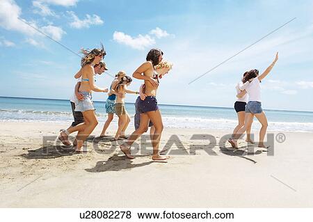 Group having a race on the beach View Large Photo Image Stock Photo - Group having a race on the beach. Fotosearch