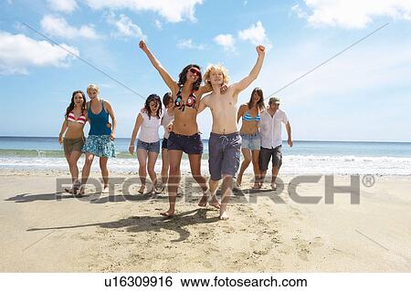 Group having a race on the beach View Large Photo Image Stock Photograph - Group having a race on the beach. Fotosearch