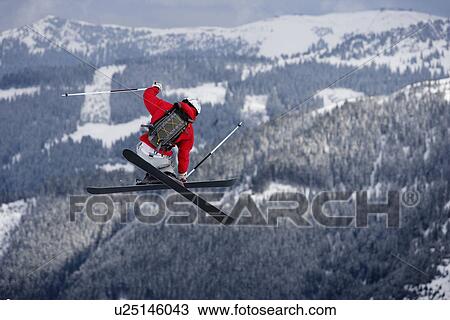 Skier jumping trees in the background View Large Photo Image Stock Image - Skier jumping trees in the background. Fotosearch