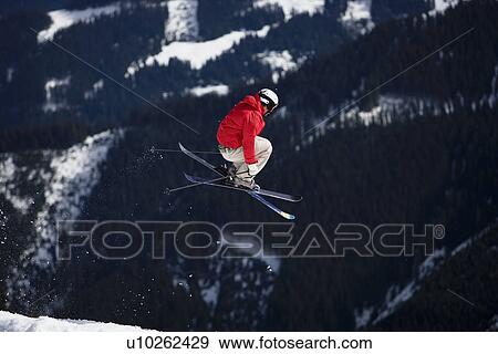 Skier jumping trees in the background View Large Photo Image Stock Photo - Skier jumping trees in the background. Fotosearch