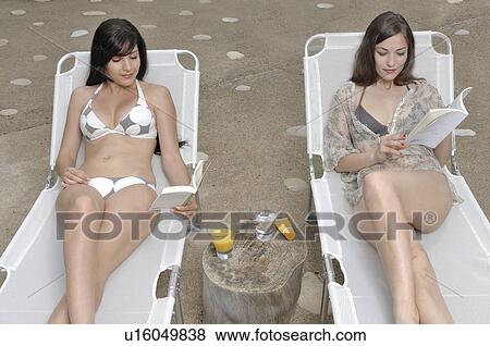 Two women reading a book View Large Photo Image Stock Photo - Two women reading a book. Fotosearch