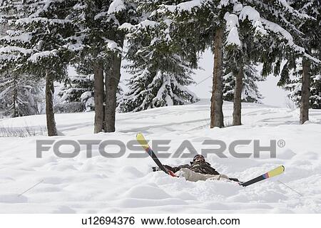 Woman lying in the snow with skis View Large Photo Image Stock Photograph - Woman lying in the snow with skis. Fotosearch