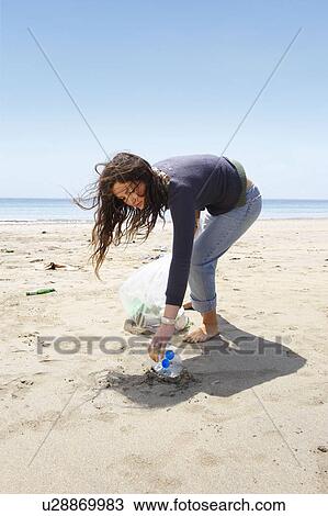 Young girl collecting garbage on beach View Large Photo Image Stock Image - Young girl collecting garbage on beach. Fotosearch