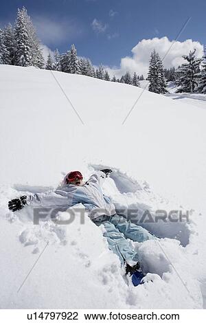 Stock Image - Young girl making a snow angel. Fotosearch