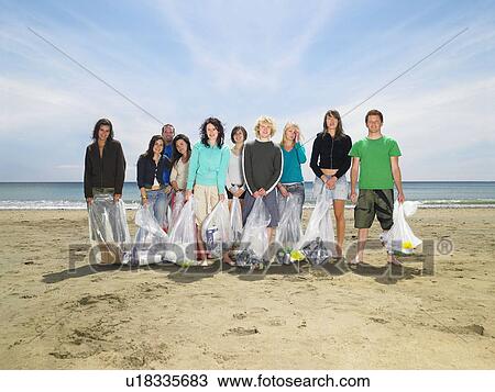 Young people collecting garbage on beach View Large Photo Image Stock Image - Young people collecting garbage on beach. Fotosearch