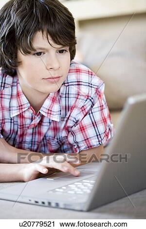Boy looking into laptop View Large Photo Image Stock Image - Boy looking into laptop. Fotosearch
