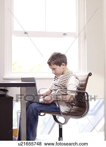 Boy on laptop in home office View Large Photo Image Stock Photo - Boy on laptop in home office. Fotosearch