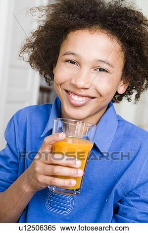 Boy smiling with a glass of orange juice View Large Photo Image Stock Photography - Boy smiling with a glass of orange juice. Fotosearch