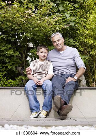 Father and son sitting outside in garden View Large Photo Image Picture - Father and son sitting outside in garden. Fotosearch