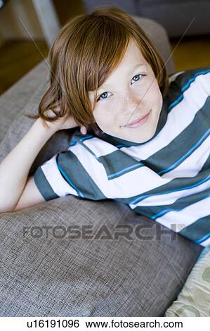 Portrait boy laying on a couch View Large Photo Image Stock Photograph - Portrait boy laying on a couch. Fotosearch