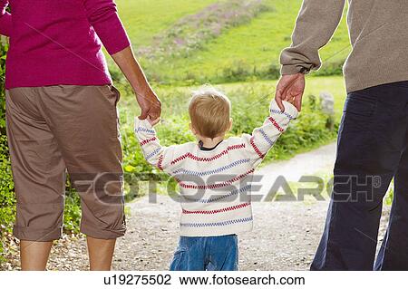 Senior couple walking with child View Large Photo Image Stock Image - Senior couple walking with child. Fotosearch