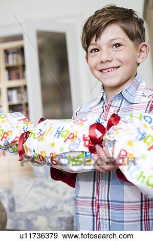 Young boy standing with birthday-present View Large Photo Image Stock Photo - Young boy standing with birthday-present. Fotosearch