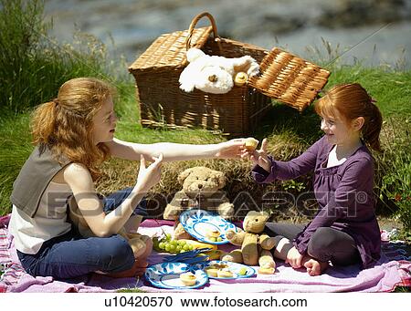 Stock Image - 2 girls having teddy bear's picnic. Fotosearch
