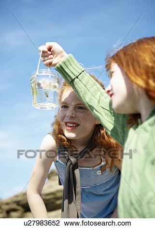 2 girls looking at fish in jar View Large Photo Image Stock Image - 2 girls looking at fish in jar. Fotosearch