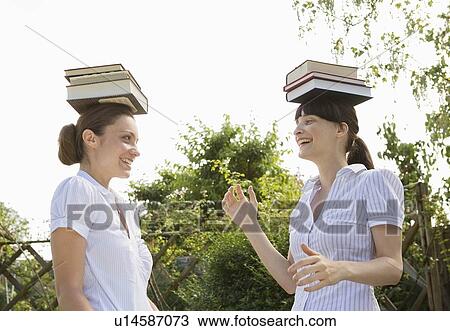 Business women balancing books on head View Large Photo Image Stock Image - Business women balancing books on head. Fotosearch