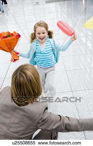 Stock Photography - Girl holding flowers running at woman. Fotosearch