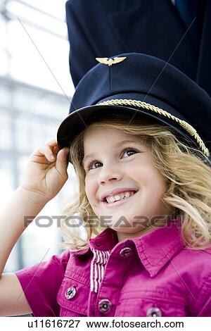 Girl wearing flight captain's hat View Large Photo Image Stock Photo - Girl wearing flight captain's hat. Fotosearch