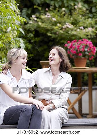 Mother and daughter sitting in garden View Large Photo Image Stock Image - Mother and daughter sitting in garden. Fotosearch