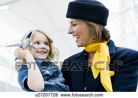 Stock Photo - Stewardess holding child in her arms. Fotosearch