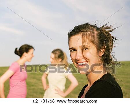 Stock Photo - Three girls, one looking to camera. Fotosearch