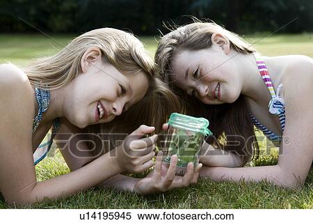 Two girls looking at jar with insects View Large Photo Image Stock Photography - Two girls looking at jar with insects. Fotosearch