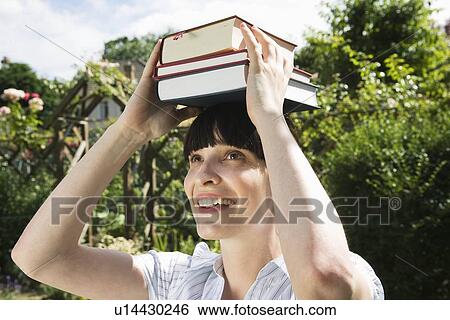 Woman balancing books on head, outside View Large Photo Image Stock Photograph - Woman balancing books on head, outside. Fotosearch