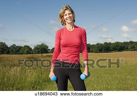 Woman exercising with dumbbells View Large Photo Image Stock Image - Woman exercising with dumbbells. Fotosearch