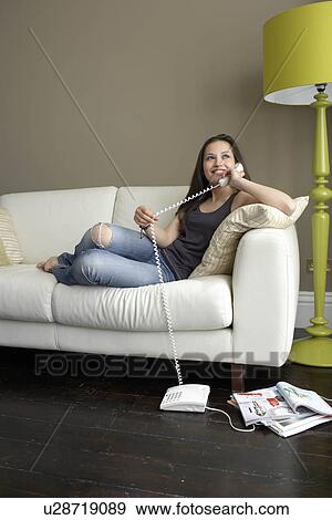 Woman on sofa using telephone View Large Photo Image Stock Photo - Woman on sofa using telephone. Fotosearch