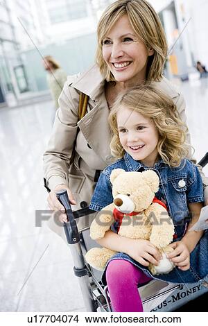 Picture - Woman pushing girl riding cart. Fotosearch