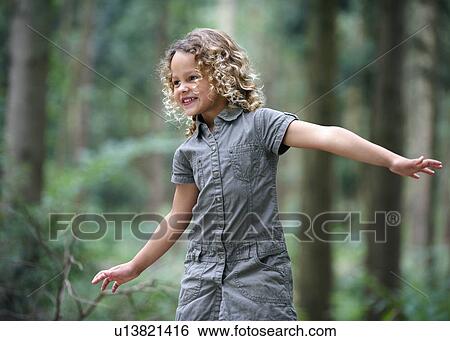 Young girl arms outstretched woodland View Large Photo Image Stock Photograph - Young girl arms outstretched woodland. Fotosearch
