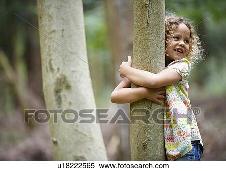 Young girl hugging tree smiling View Large Photo Image Stock Photography - Young girl hugging tree smiling. Fotosearch