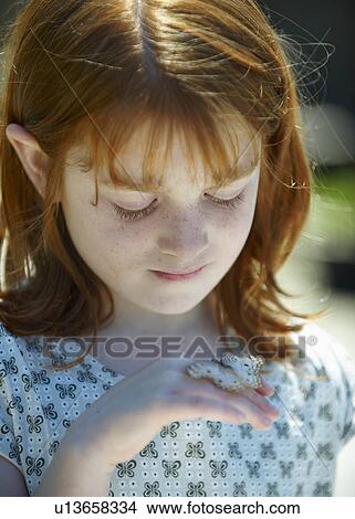 Young girl looking at butterfly View Large Photo Image Picture - Young girl looking at butterfly. Fotosearch