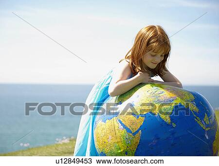 Young girl looking at inflatable globe View Large Photo Image Stock Image - Young girl looking at inflatable globe. Fotosearch