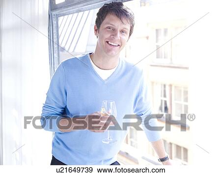 Man by window with wine glass View Large Photo Image Stock Photo - Man by window with wine glass. Fotosearch