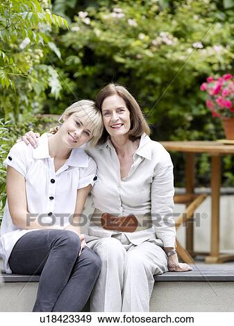 Mother and daughter sitting in garden View Large Photo Image Stock Photo - Mother and daughter sitting in garden. Fotosearch
