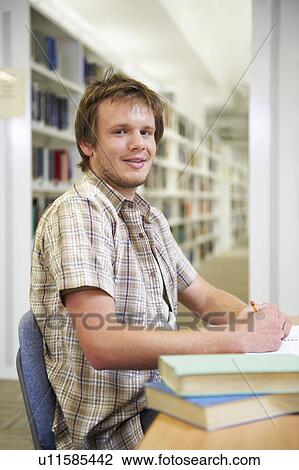 Stock Image - Portrait of young man in library. Fotosearch