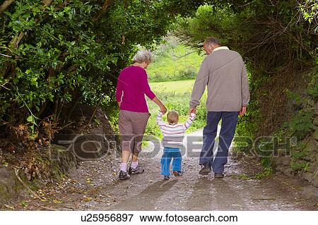 Senior couple walking with child View Large Photo Image Stock Photo - Senior couple walking with child. Fotosearch