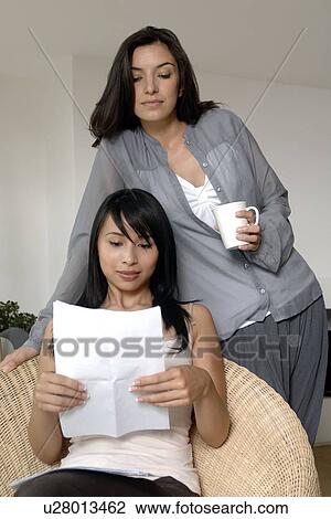 Two women reading a letter View Large Photo Image Stock Image - Two women reading a letter. Fotosearch