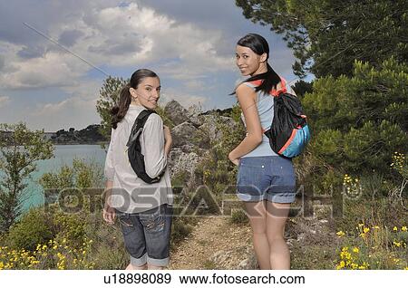 Two women walking through nature View Large Photo Image Stock Photo - Two women walking through nature. Fotosearch