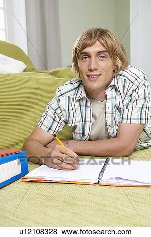 Young man doing home work on rug View Large Photo Image Stock Photo - Young man doing home work on rug. Fotosearch