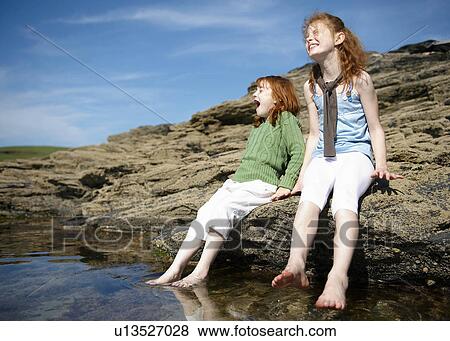 2 girls putting feet in cold rock pool View Large Photo Image Stock Photo - 2 girls putting feet in cold rock pool. Fotosearch