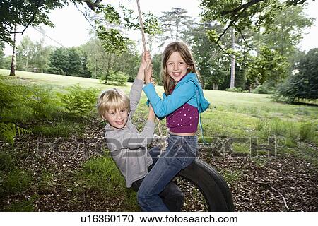 Boy and girl on tire swing View Large Photo Image Stock Image - Boy and girl on tire swing. Fotosearch