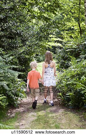 Boy and girl walking through forest View Large Photo Image Stock Image - Boy and girl walking through forest. Fotosearch