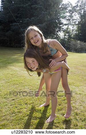 Girl piggyback on another girl View Large Photo Image Stock Image - Girl piggyback on another girl. Fotosearch