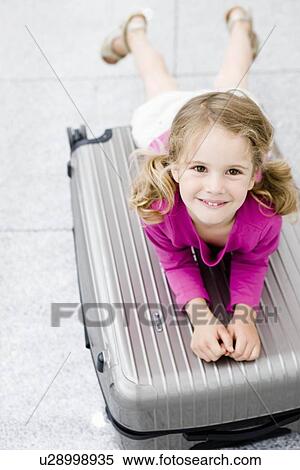Girl smiling leaning on suitcase View Large Photo Image Stock Photography - Girl smiling leaning on suitcase. Fotosearch
