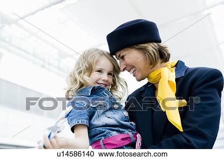 Stock Image - Stewardess holding child in her arms. Fotosearch