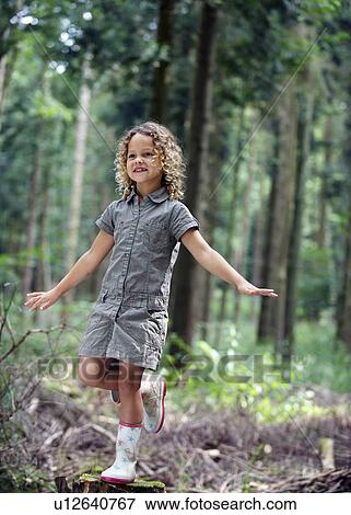 Young girl balancing in woodland View Large Photo Image Stock Photo - Young girl balancing in woodland. Fotosearch